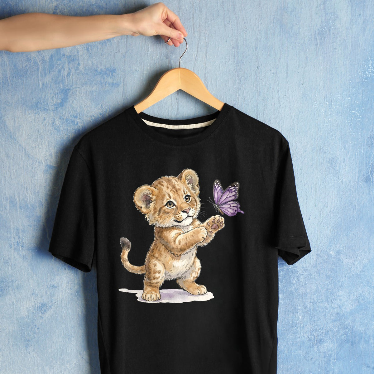 Bügelbild: Löwenbaby streckt Pfote aus inkl. Anleitung – auf schwarzem T-Shirt